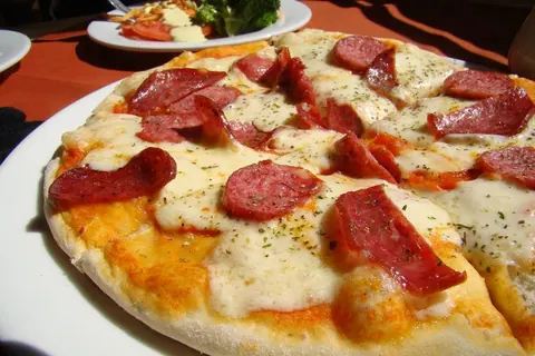 Pizza mit Salami und geschmolzenem Mozzarella