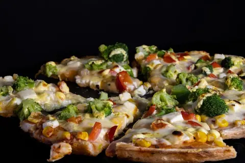 Pizzastücke mit Hähnchen, Brokkoli und Mais