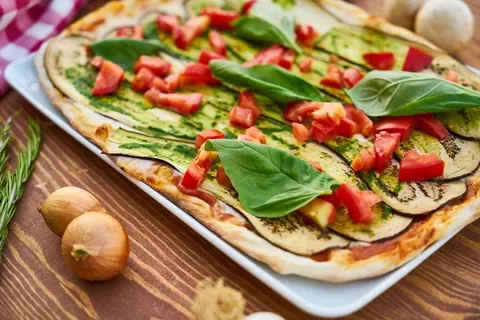 Pizza mit gegrilltem Gemüse und Basilikum