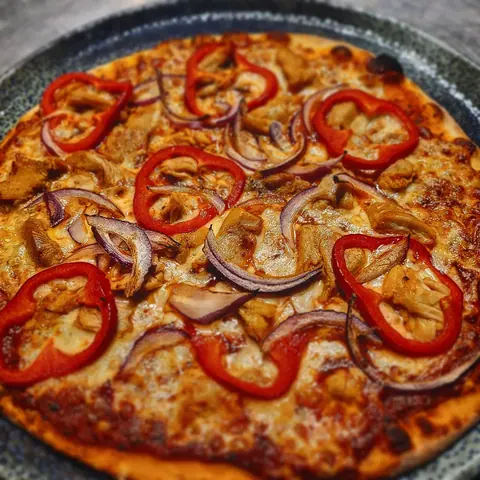 Pizza mit Paprikaringen und roten Zwiebeln