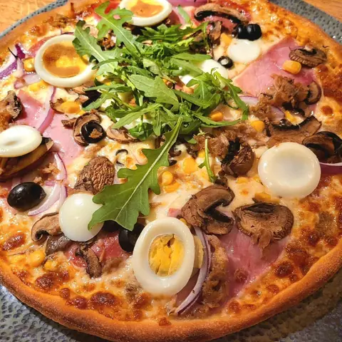 Pizza mit Ei, Schinken, Champignons und Mais