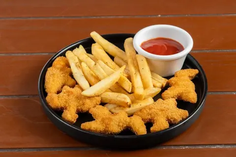 Kinder-Nuggets in Dinoform mit Pommes und Ketchup