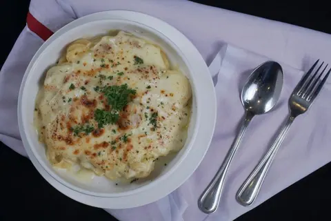 Überbackenes Nudelgericht mit Käse und Petersilie