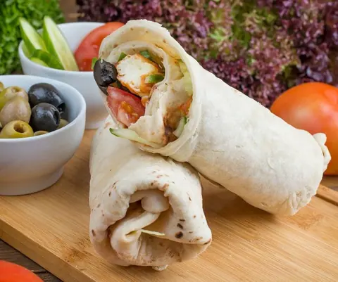 Gefüllte Hähnchen-Wraps auf einem Holzbrett