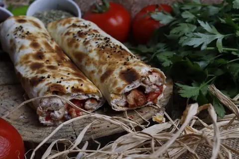 Zwei gegrillte Fleisch-Rollen im Lavash mit Tomaten und Petersilie
