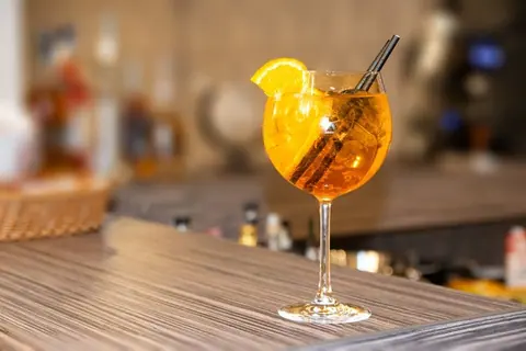 Aperol Spritz mit Orangenscheibe auf einem Holztisch