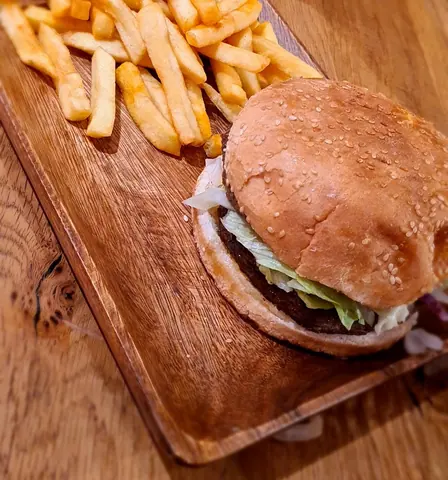 Hamburger mit Pommes auf einem Holzbrett
